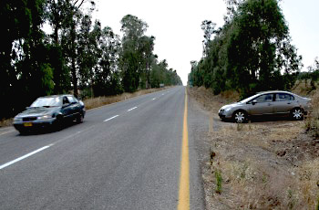 ¿Cómo se conducirá el conductor de un vehículo que sale de un camino de tierra e intenta subir al camino pavimentado?