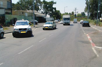 בתמונה שלפניך, תגובת הנוהגים בדרך לרכב היוצא מהחנייה אינה ברורה. כיצד צריך להגיב נהג המשאית במצב זה?