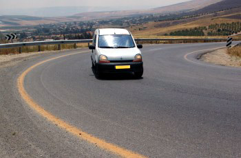 In your opinion, is the white vehicle within the curve positioned correctly?